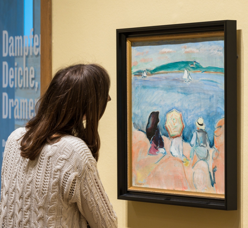Besucherin betrachtet ein Gemälde von Arne Kavli